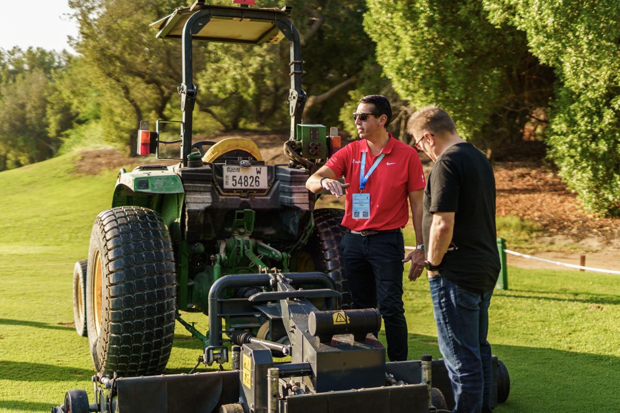 Delegates discussing turf maintenance machinery